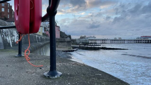 Time lapse of Cromer pier in Norfolk, UK at sunset with a high tide.