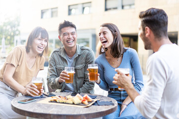 Happy multiracial friends group drinking beer at brewery pub restaurant - Friendship concept with...