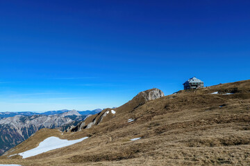 Hiking trail leading to mount Eisenerzer Reichenstein in Styria, Austria, Europe. Austrian Alps. Bare mountain ridges of Ennstal Alps with view on the Reichensteinhuette. Summit cross on the peak