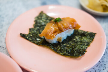 Single-serve sushi made of squid placed on seaweed plate