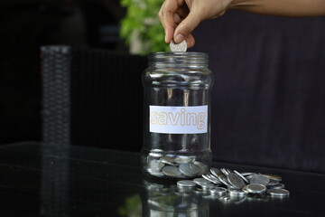 businessman holding coins putting in glass. concept saving money for finance accounting. Indonesian rupiah notes in one hundred thousand denominations and rupiah coins