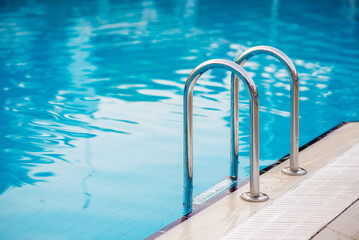 Obraz premium Swimming pool with stair and wooden deck at hotel.