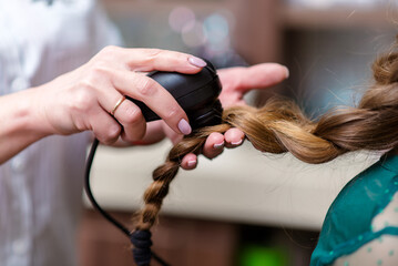 Close-up of hairdresser examining client hair with a special apparatus for diagnostic hair and...