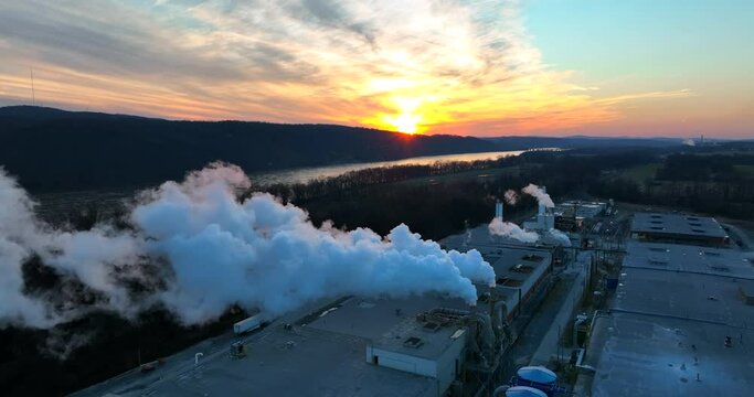 Blue collar factory jobs in USA. Manufacturing plant facility at sunset. Aerial establishing shot of company in America.