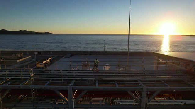 Pipe line conection in oil refinery at dusk twilight near the sea