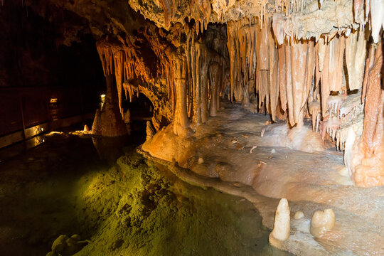 Grotte karstique avec un petit lac transparent et sans rides surplomb&eacute; par des stalactites et des colonnes calcaires. Grotte de Fontrabiouse, Pyr&eacute;n&eacute;es fran&ccedil;aises