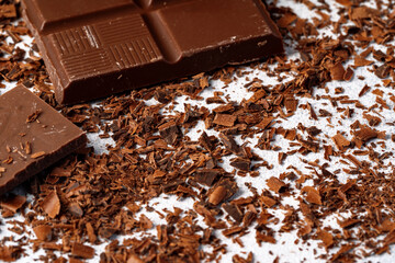 Grated chocolate and pieces of tasty chocolate on table
