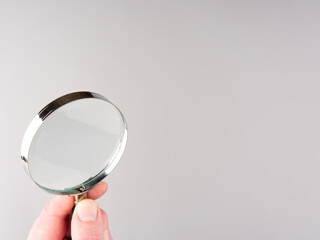 Magnifying glass on a gray background. Space for text