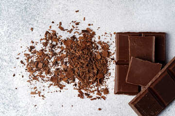 Grated chocolate and pieces of tasty chocolate on table