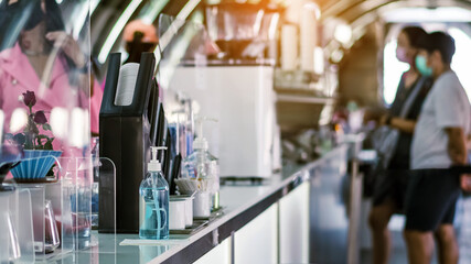 Blue alcohol gel bottle for hand cleaning to prevent the spreading of the Coronavirus (Covid-19) on counter to service for customers at cafe or coffee shop. Healthcare concept. New normal lifestyle.