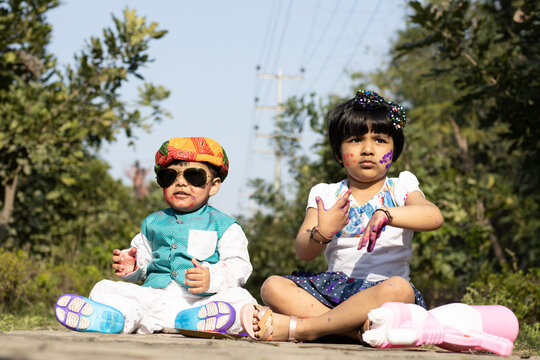 Happy Asian Indian Kids Boy And Girl Enjoying The Festival Of Colors With Holi Color Powder Called Gulal Or Rang