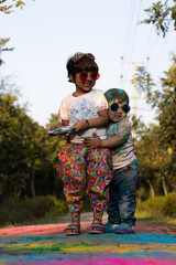 Happy Asian Indian Kids Boy And Girl Enjoying The Festival Of Colors With Holi Color Powder Called Gulal Or Rang