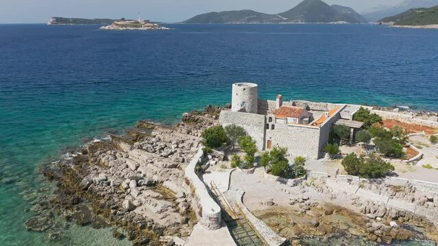 Castle on the island of Otocic Gospa in the Bay of Kotor. Montenegro. Top view of the island with a fortress. Drone. Pleasure boats in the bay. 
