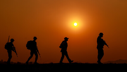 silhouette action soldiers walking and hold weapons background is sunset white balance ship effect
