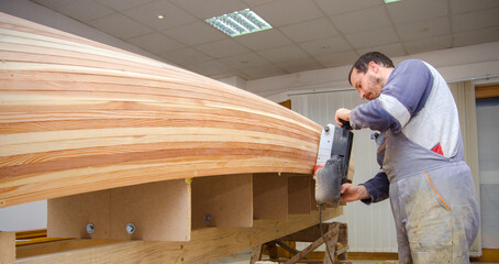 Carpenter making wooden boat in carpenter workshop.