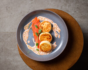 Cottage cheese pancakes, cream sauce with caviar, salmon and greens (  syrniki )