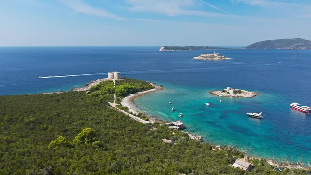 Top view of the island with a fortress. View from the Lustica peninsula to the island of Otocic Gospa. Castle on the island of Otocic Gospa. Montenegro. Drone. Catamarans in bay. Pleasure boats in the