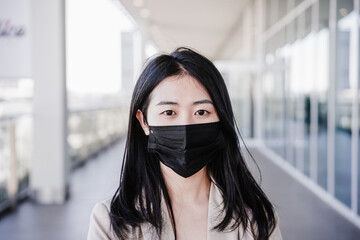 close up of young business woman wearing face mask in city. corona virus concept