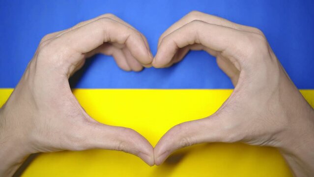 Hand heart on a Ukraine flag
