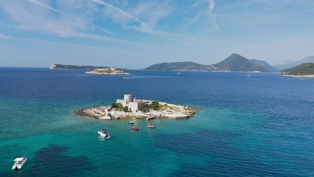 Castle on the island of Otocic Gospa in the Bay of Kotor. Montenegro. Top view of the island with a fortress. Drone. Pleasure boats in the bay. 
