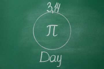 The Greek letter Pi is drawn in chalk on a green school blackboard in a circle in honor of the international day of March 14