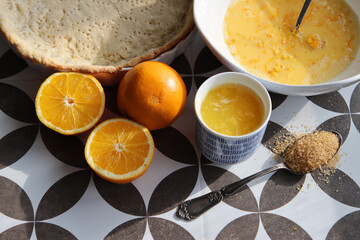 Making orange pie. Close up photo of fresh ingredients. Crusty dough, oranges, sugar, eggs top view photo. 