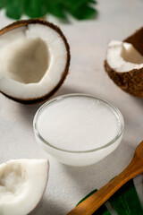 Fototapeta na wymiar Coconut oil with fresh nut pieces. Healthy food. Bright background.
