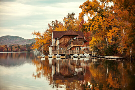 Old boathouse on the side of a lake during the fall - Powered by Adobe