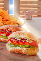 Hot dogs on wooden board in sunny cafe