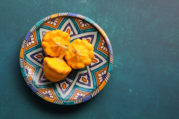 Patty pan squash on decorative ceramic plate. Sill life with vegetables. Beautiful yellow patty pan...
