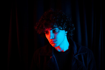 Melancholic guy on dark background.
