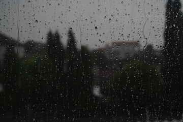 rain water wets the glass windows of the house