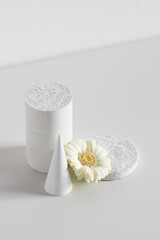 stone figures from natural material with flower on white background, Concept minimal decoration in interior at home, vertical.