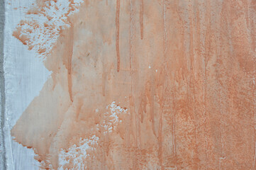 Dripping wall paint forms beautiful art. white wall with orange paint drops.