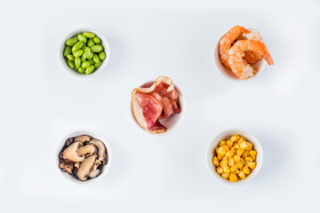 Shrimps, beans, pickled corn, pickled mushrooms, bacon in a bowl. View from above. Flat lay
