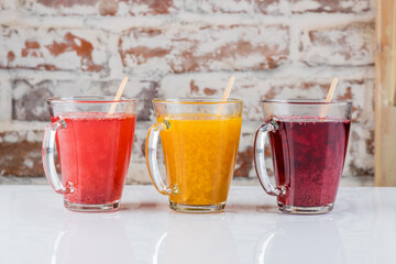 Hot drinks with berries in transparent mugs. Fruit drink, mulled wine, ginger, sea buckthorn drink