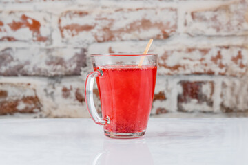 Hot drink with red berries in a transparent mug. Morse, mulled wine
