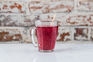Hot drink with red berries in a transparent mug. Morse, mulled wine