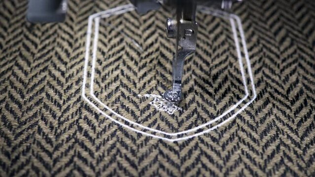 Embroidery design alphabet monogram D on brown fabrics embroider by machine. Close up. 4k video
