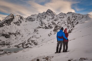 Beautiful winter mountain landscape. Couple in love on a trail in the Polish Tatra Mountains.