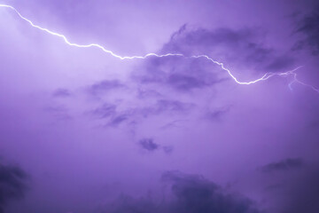 Lightning stroke in purple night sky