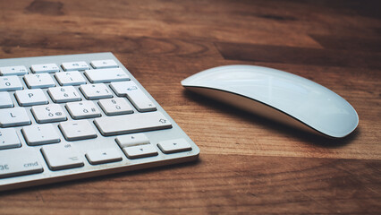 White mouse and keyboard on wooden table