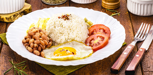 Brazilian meal, lunch with rice, beans, fried egg, french fries, farofa and salad