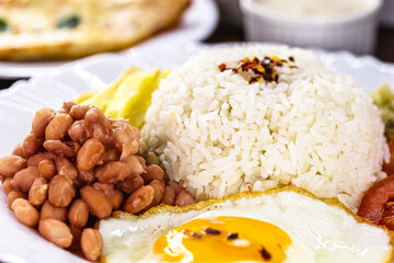 rice dish with beans typical of brazil, fried egg and salad, homemade food