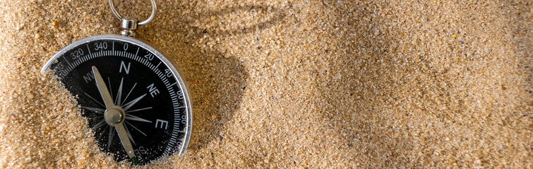 Compass on the sand at the beach. Concept of travel or direction.