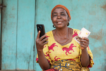 happy elderly african woman holding some money and phone