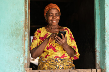 smiling elderly african woman using her phone - Powered by Adobe