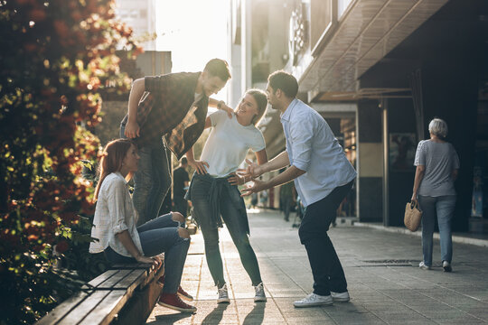 Young friends hang out on the city street.They go for walks together and have fun in the city downtown.
