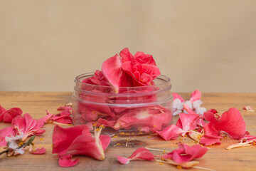 Beauty product container filled with fresh dark pink flower petals. Idea for natural cosmetics mock up. 