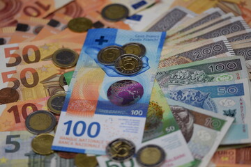 Swiss francs and Polish zlotys on euros banknotes background, credit in francs, frankowicze, kredyt we frankach szwajcarskich, franki szwajcarskie, Switzerland money banknotes, ask for money, debt.